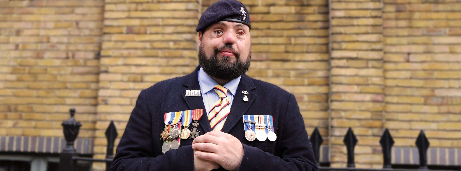 Photo of blind veteran Simon wearing his service medals